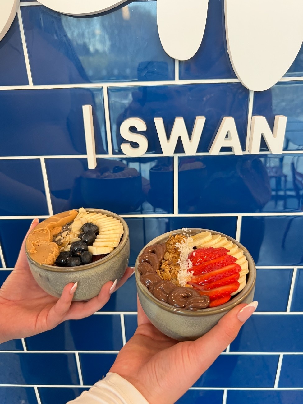 Açaí bowls held against Eala's blue tiled wall